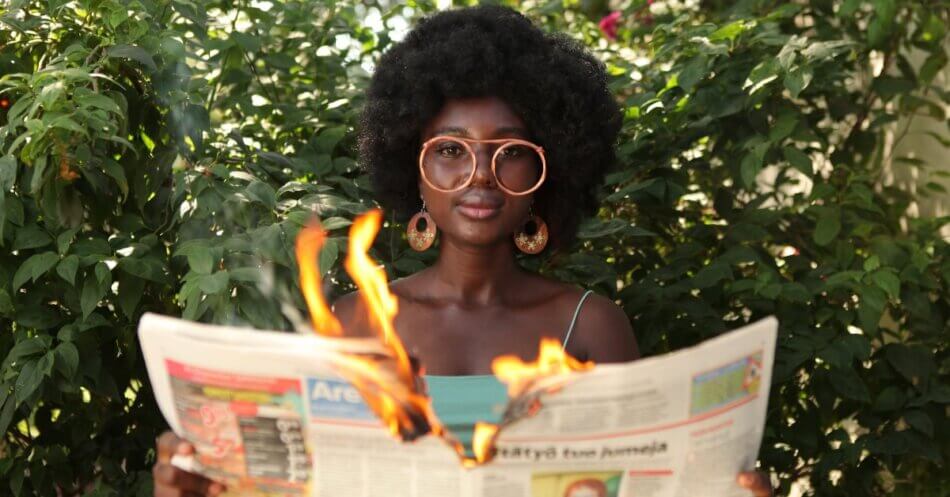 anxious woman reading newspaper on fire