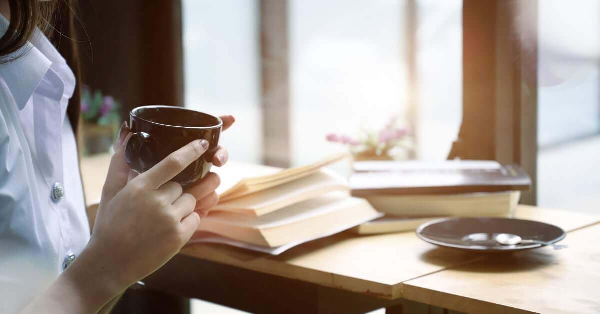 woman enjoying a warm drink while reading